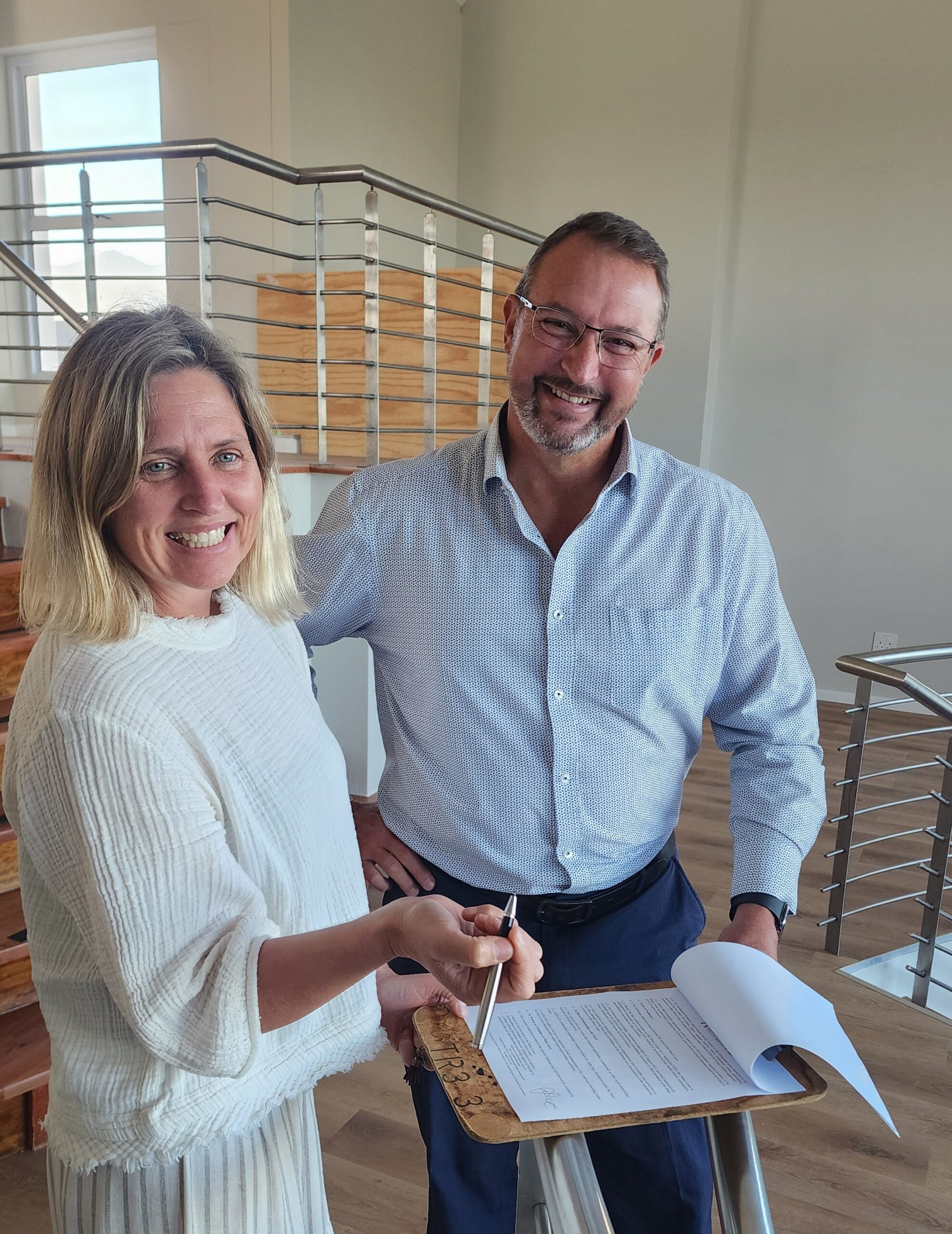 Willem Jacobs CEO of Kingswood Golf Estate Home Owners Association hands over the lease to Suzanne Smit of Pure Movement lease handover kingswood golf estate pure movement studio